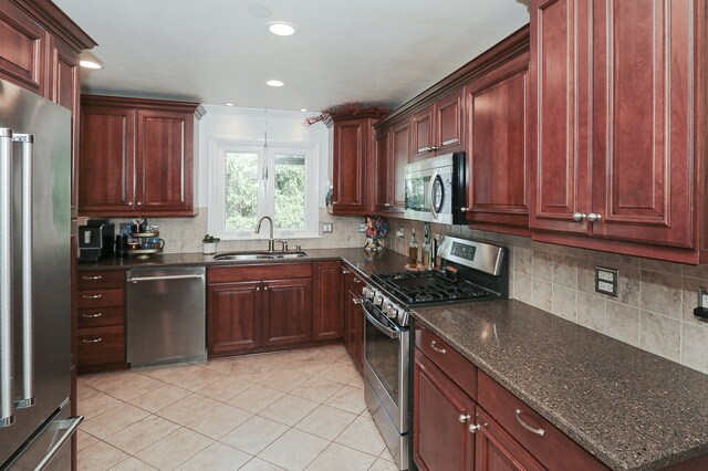 110 Tudor Dr, Barrington, IL 60010 - kitchen featuring appliances with stainless steel finishes, light tile patterned floors, decorative backsplash, dark stone countertops, and recessed lighting