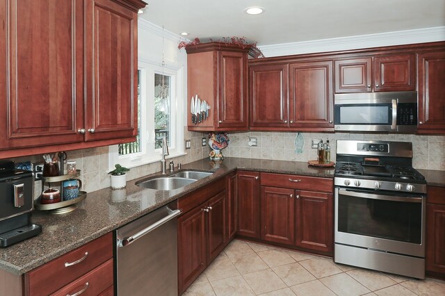 110 Tudor Dr, Barrington, IL 60010 - kitchen featuring stainless steel appliances, light tile patterned floors, dark stone countertops, tasteful backsplash, and crown molding