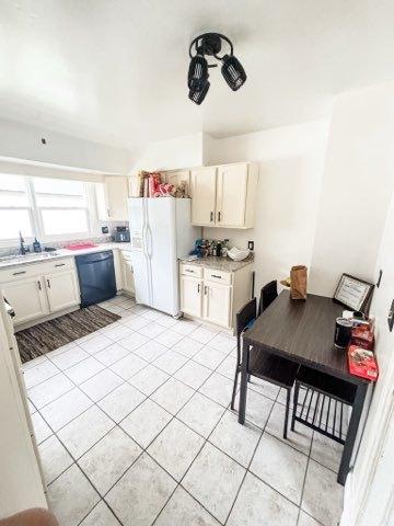 221 E Main St, Genoa, IL 60135 - kitchen featuring white fridge with ice dispenser, dishwasher, light tile patterned flooring, and light countertops