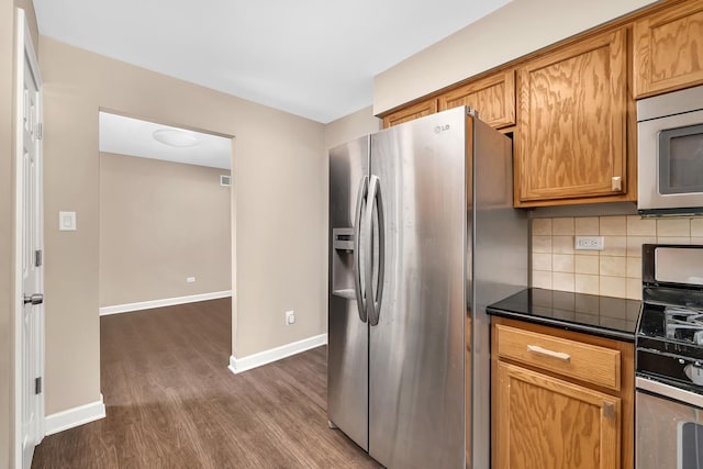 2314 Hasting Dr, Plainfield, IL 60586 - kitchen with stainless steel appliances, dark wood finished floors, dark countertops, decorative backsplash, and brown cabinetry