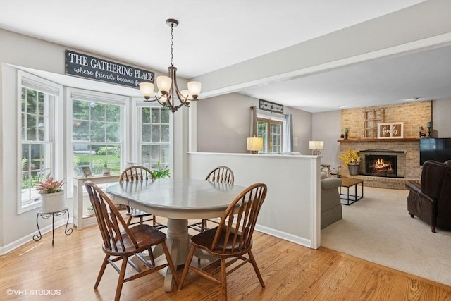 2325 Fairfax Rd, Saint Charles, IL 60174 - dining room with a chandelier, light wood-style flooring, and a fireplace