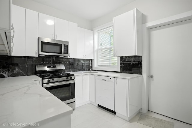 3425 W Carroll Ave, Chicago, IL 60624 - kitchen featuring stainless steel appliances, tasteful backsplash, white cabinetry, and light stone countertops