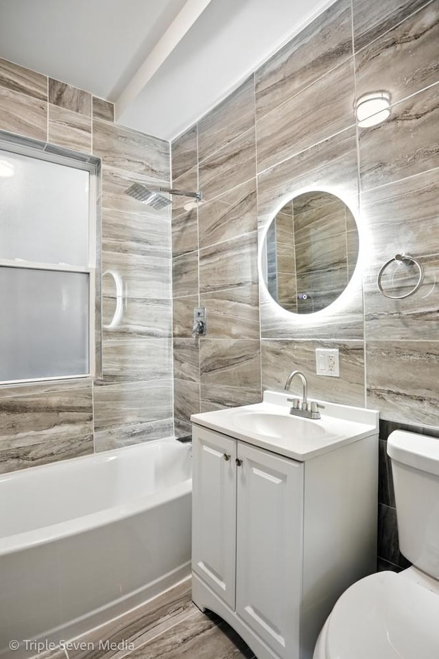 3425 W Carroll Ave, Chicago, IL 60624 - bathroom featuring tile walls, vanity, and shower / washtub combination