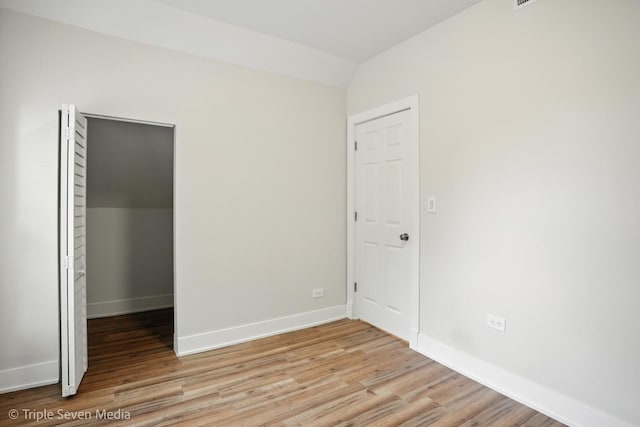 3425 W Carroll Ave, Chicago, IL 60624 - unfurnished bedroom featuring light wood finished floors, vaulted ceiling, a spacious closet, and a closet