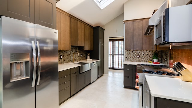 908 Claremont Dr, Downers Grove, IL 60516 - kitchen featuring appliances with stainless steel finishes, lofted ceiling, light countertops, a skylight, and backsplash