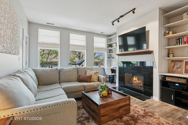 1255 N Orleans St Unit 1103, Chicago, IL 60610 - living room with wood finished floors, healthy amount of natural light, a tile fireplace, and built in features