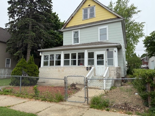 670 S Martin Luther King Jr Ave, Waukegan, IL 60085 - american foursquare style home featuring brick siding, a gate, a fenced front yard, a shingled roof, and entry steps