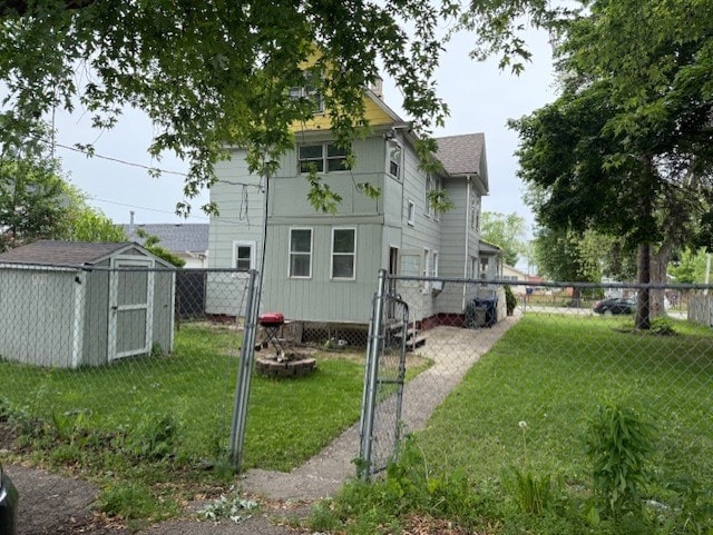 670 S Martin Luther King Jr Ave, Waukegan, IL 60085 - back of property with a fenced backyard, a storage shed, roof with shingles, a chimney, and a gate