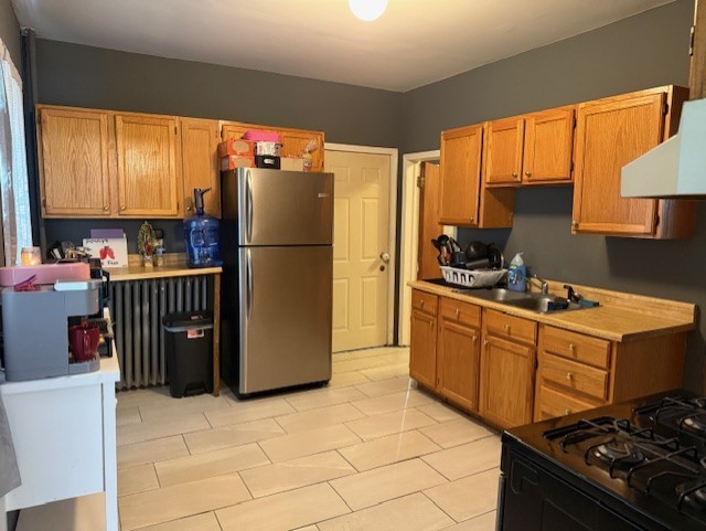 670 S Martin Luther King Jr Ave, Waukegan, IL 60085 - kitchen featuring freestanding refrigerator, light countertops, exhaust hood, and light tile patterned floors