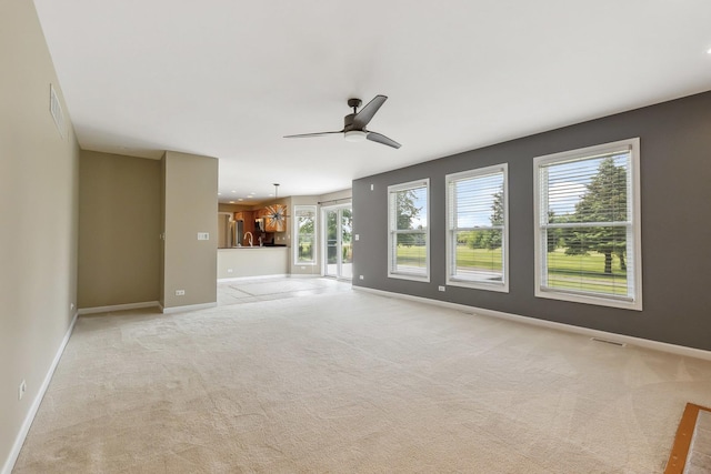 200 Saint Andrews Dr, Dekalb, IL 60115 - unfurnished living room featuring light carpet, a ceiling fan, and a chandelier