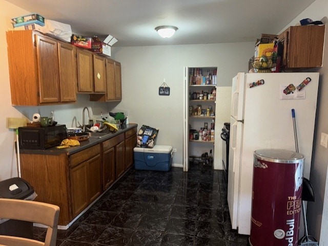 3007 30th St, Zion, IL 60099 - kitchen with freestanding refrigerator, black microwave, brown cabinets, and dark countertops