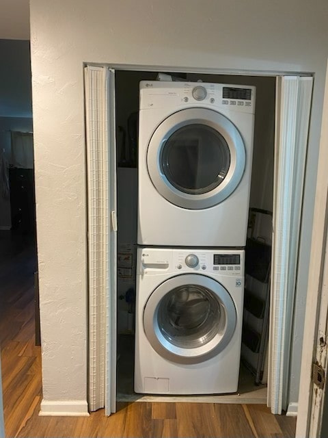 3007 30th St, Zion, IL 60099 - laundry area featuring stacked washer and clothes dryer, wood finished floors, and a textured wall
