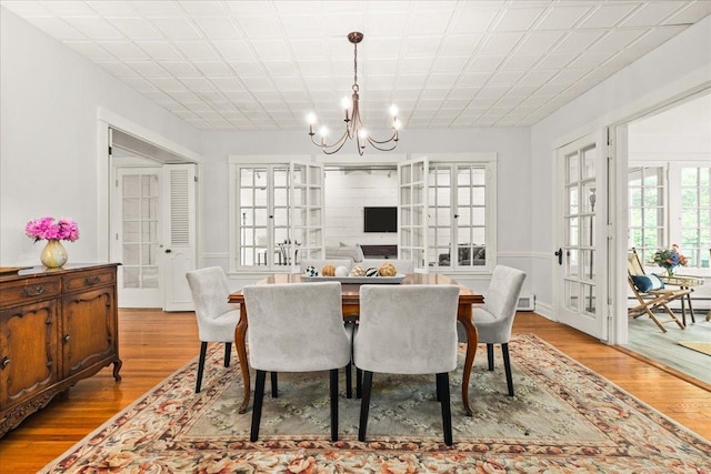 633 Forest Ave, Wilmette, IL 60091 - dining area with a chandelier, wood finished floors, and french doors