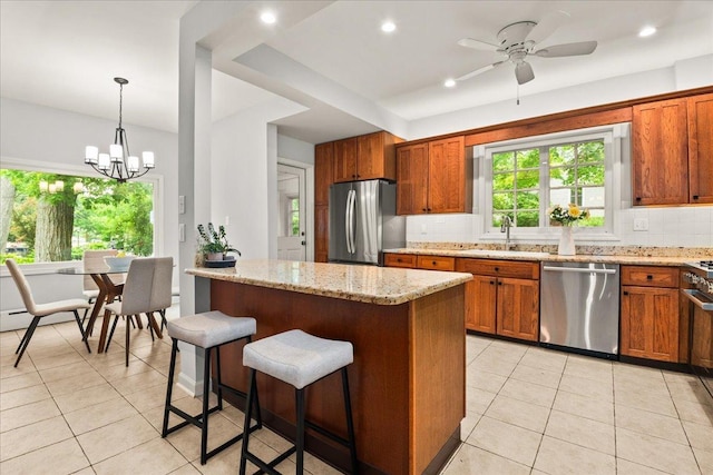 633 Forest Ave, Wilmette, IL 60091 - kitchen with appliances with stainless steel finishes, decorative backsplash, light tile patterned flooring, a kitchen breakfast bar, and brown cabinetry
