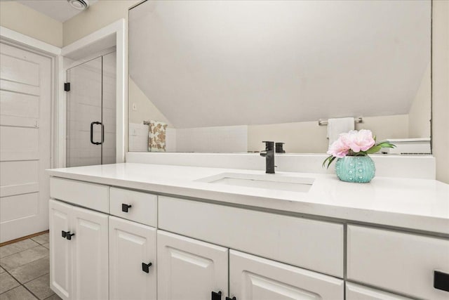 633 Forest Ave, Wilmette, IL 60091 - bathroom featuring lofted ceiling, vanity, a stall shower, and tile patterned flooring
