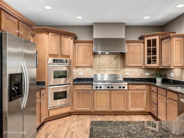 508 Gene Darfler Ct, Naperville, IL 60565 - kitchen featuring stainless steel appliances, wall chimney exhaust hood, light wood-style flooring, dark stone countertops, and glass insert cabinets