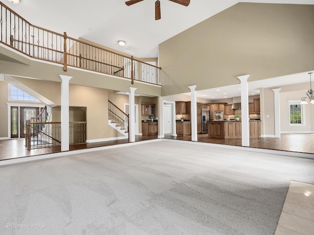 508 Gene Darfler Ct, Naperville, IL 60565 - unfurnished living room featuring a high ceiling, decorative columns, ceiling fan, healthy amount of natural light, and stairs