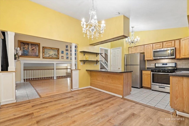 1018 Bob O Link Ln, Darien, IL 60561 - kitchen featuring stainless steel appliances, a chandelier, dark countertops, light wood-style flooring, and backsplash
