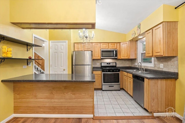 1018 Bob O Link Ln, Darien, IL 60561 - kitchen featuring stainless steel appliances, a peninsula, dark countertops, lofted ceiling, and decorative backsplash