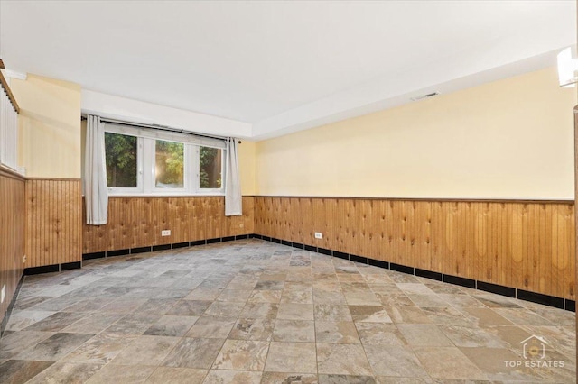 1018 Bob O Link Ln, Darien, IL 60561 - unfurnished room featuring a wainscoted wall, stone finish flooring, and wooden walls