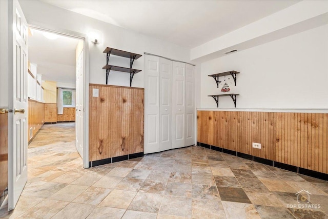 1018 Bob O Link Ln, Darien, IL 60561 - empty room featuring wainscoting, wooden walls, and stone finish flooring