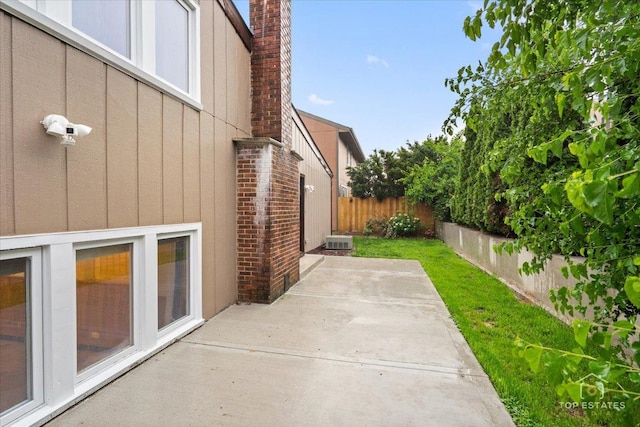 1018 Bob O Link Ln, Darien, IL 60561 - view of home's exterior featuring board and batten siding, a patio, a fenced backyard, and a chimney
