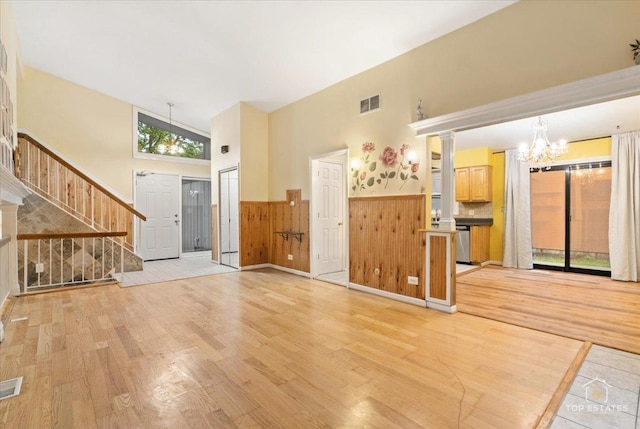 1018 Bob O Link Ln, Darien, IL 60561 - unfurnished living room with light wood-type flooring, a chandelier, a wainscoted wall, stairway, and a high ceiling