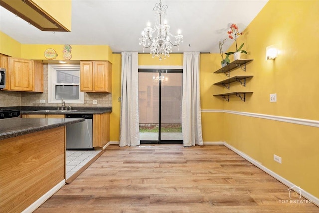 1018 Bob O Link Ln, Darien, IL 60561 - kitchen featuring appliances with stainless steel finishes, light wood-style flooring, dark countertops, a chandelier, and decorative backsplash