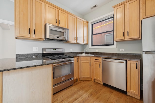 1709 N Paulina St Unit 303, Chicago, IL 60622 - kitchen with appliances with stainless steel finishes, light brown cabinets, light wood-type flooring, and dark stone countertops