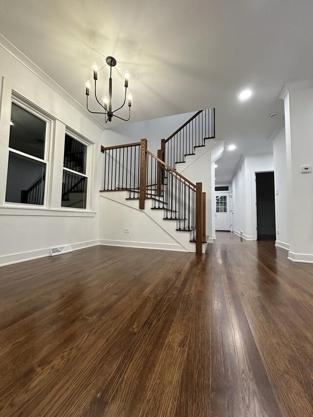 4843 W Schubert Ave, Chicago, IL 60639 - unfurnished living room featuring a chandelier, stairs, wood finished floors, and crown molding