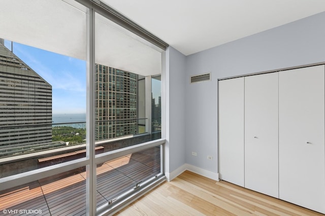 8 E Randolph St Unit 3203, Chicago, IL 60601 - unfurnished bedroom featuring wood finished floors, a water view, and a closet