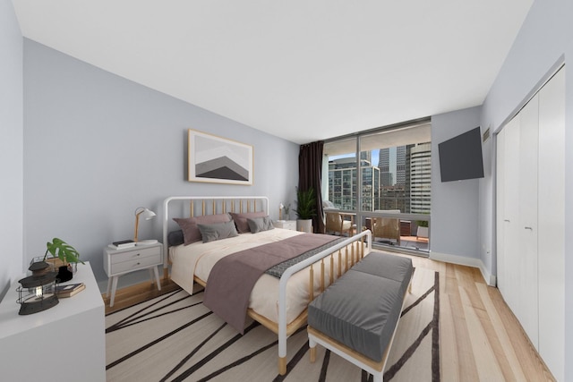 8 E Randolph St Unit 3203, Chicago, IL 60601 - bedroom featuring light wood-style floors, a closet, and a wall of windows