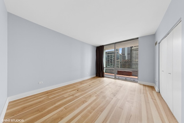 8 E Randolph St Unit 3203, Chicago, IL 60601 - unfurnished bedroom featuring wood finished floors, a closet, and a wall of windows