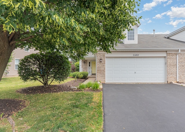 21402 Carlton St, Crest Hill, IL 60403 - obstructed view of property with brick siding, asphalt driveway, an attached garage, a front lawn, and a shingled roof