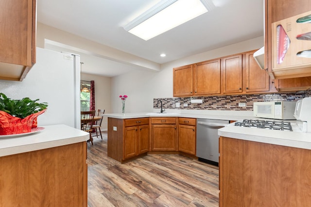 21402 Carlton St, Crest Hill, IL 60403 - kitchen with white appliances, a peninsula, wood finished floors, backsplash, and brown cabinetry
