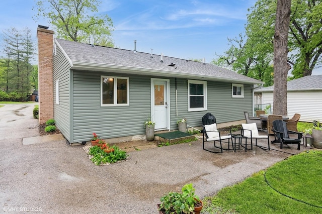2365 N Barrington Woods Rd, Palatine, IL 60074 - rear view of house featuring a chimney, roof with shingles, and a patio area