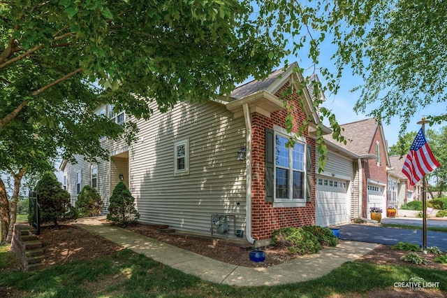 1568 Sedona Ave, Aurora, IL 60504 - view of property exterior featuring an attached garage, brick siding, driveway, and roof with shingles