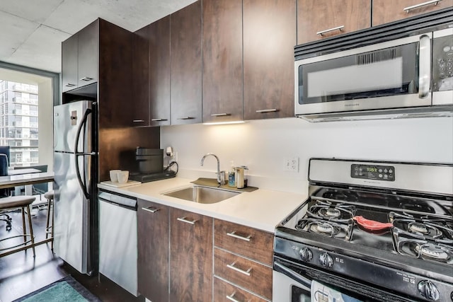 659 W Randolph St Unit 1115, Chicago, IL 60661 - kitchen with appliances with stainless steel finishes, light countertops, dark brown cabinetry, and modern cabinets
