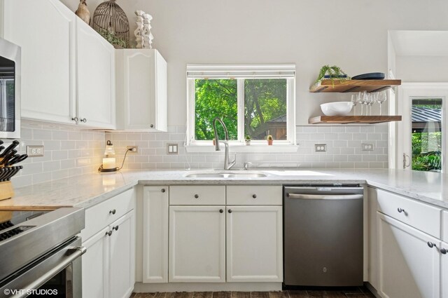 2570 Fairfax Ln, Lake In The Hills, IL 60156 - kitchen featuring stainless steel dishwasher, decorative backsplash, and white cabinetry