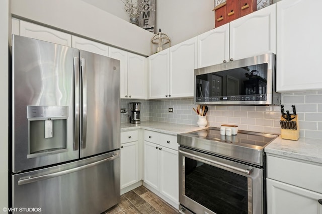 2570 Fairfax Ln, Lake In The Hills, IL 60156 - kitchen with appliances with stainless steel finishes, tasteful backsplash, white cabinetry, and light stone counters