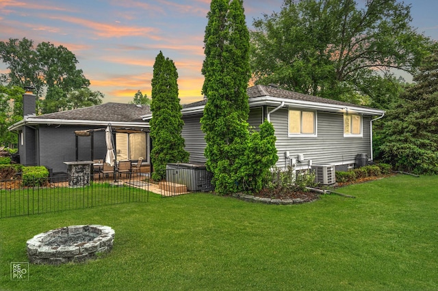12620 S Kinvarra Dr, Palos Park, IL 60464 - back of property at dusk with a chimney, a fire pit, and a patio area