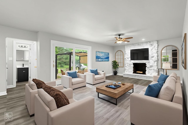 12620 S Kinvarra Dr, Palos Park, IL 60464 - living room featuring a ceiling fan, light wood-type flooring, a stone fireplace, and recessed lighting