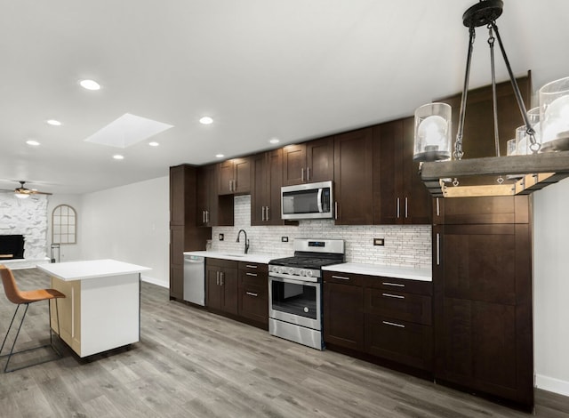12620 S Kinvarra Dr, Palos Park, IL 60464 - kitchen featuring stainless steel appliances, a skylight, light countertops, backsplash, and recessed lighting