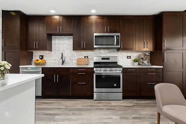 12620 S Kinvarra Dr, Palos Park, IL 60464 - kitchen with stainless steel appliances, light countertops, light wood-style floors, tasteful backsplash, and recessed lighting