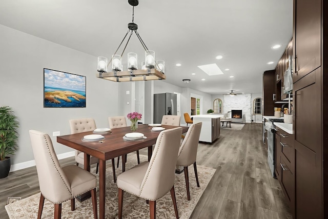 12620 S Kinvarra Dr, Palos Park, IL 60464 - dining room featuring a skylight, light wood-type flooring, recessed lighting, a chandelier, and a large fireplace