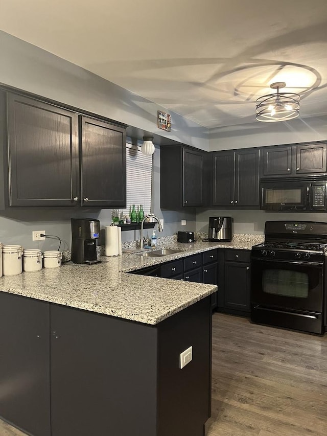 142 Sedgewicke Dr, Romeoville, IL 60446 - kitchen with black appliances, light stone countertops, wood finished floors, a peninsula, and dark cabinets