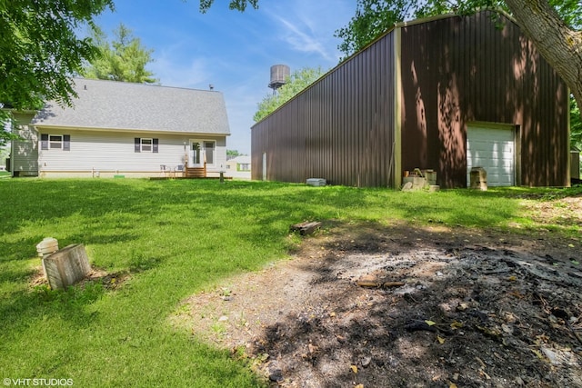 32597 Genoa Rd, Genoa, IL 60135 - rear view of house with a lawn, an outdoor structure, and a detached garage