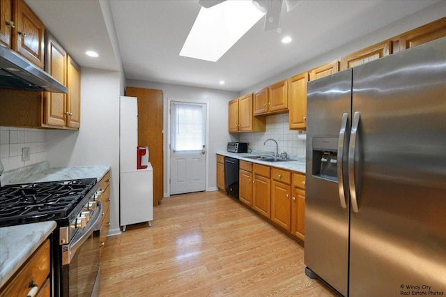 36 W Green Meadows Blvd, Streamwood, IL 60107 - kitchen with stainless steel appliances, ventilation hood, tasteful backsplash, light wood-style floors, and a skylight