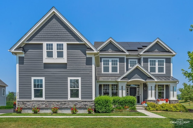 3578 Doral Dr, Elgin, IL 60124 - craftsman-style home featuring a standing seam roof, solar panels, stone siding, a front lawn, and a metal roof