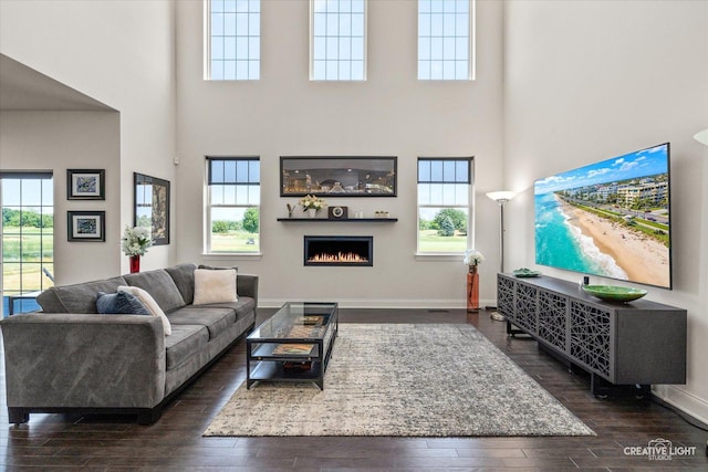 3578 Doral Dr, Elgin, IL 60124 - living area with a towering ceiling, dark wood-type flooring, a lit fireplace, and plenty of natural light